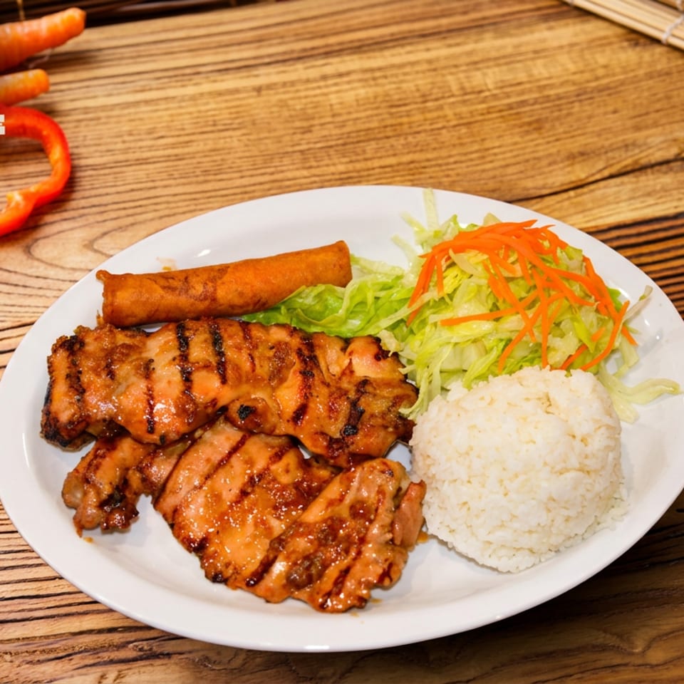 Vietnamese grilled chicken, spring roll, rice, and fresh salad on a white plate.